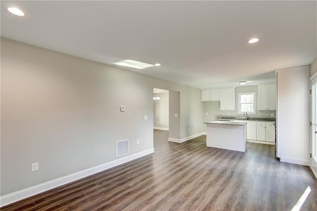 kitchen featuring a center island, white cabinetry, dark wood-type flooring, and sink