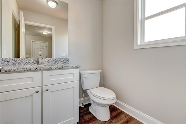 bathroom with hardwood / wood-style flooring, vanity, and toilet