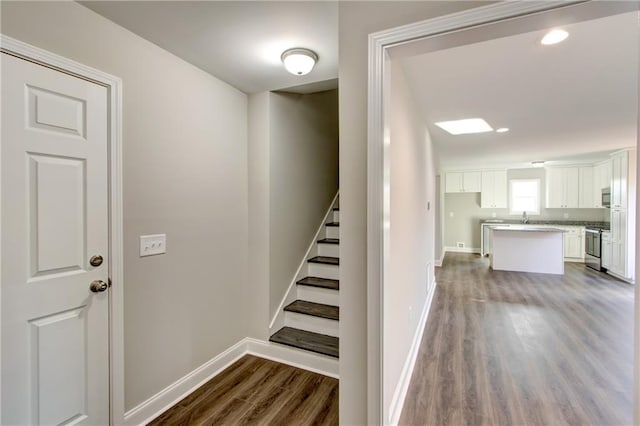 stairway with hardwood / wood-style floors and sink