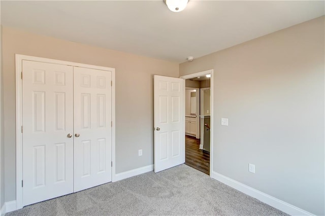 unfurnished bedroom featuring light colored carpet and a closet