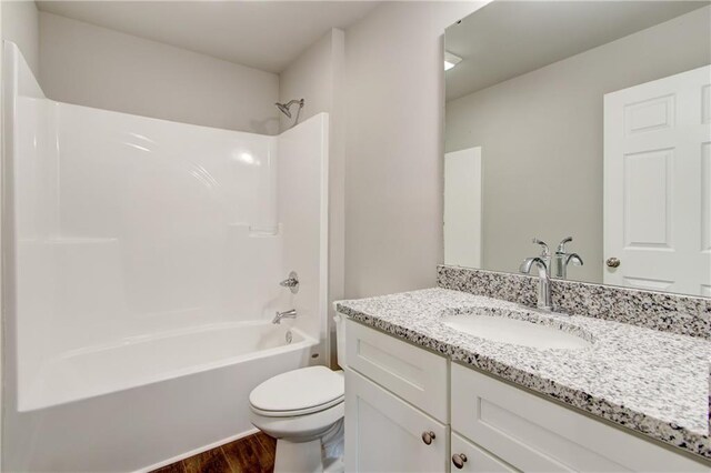 full bathroom featuring hardwood / wood-style floors, vanity, toilet, and tub / shower combination