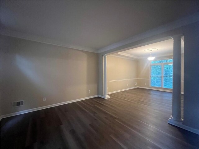 spare room with crown molding and dark wood-type flooring