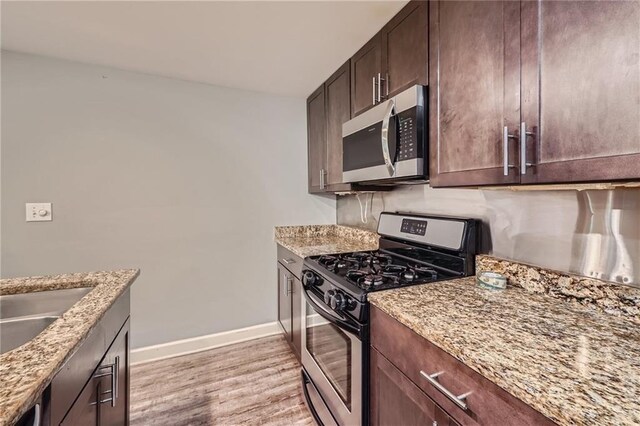 3046 Briarcliff Rd NE Unit 15, Atlanta, GA 30329 - kitchen with stainless steel appliances, baseboards, light wood-style flooring, light stone countertops, and dark brown cabinets