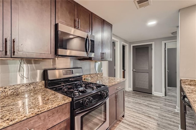 3046 Briarcliff Rd NE Unit 15, Atlanta, GA 30329 - kitchen with stainless steel appliances, light stone countertops, baseboards, dark brown cabinets, and light wood-style floors