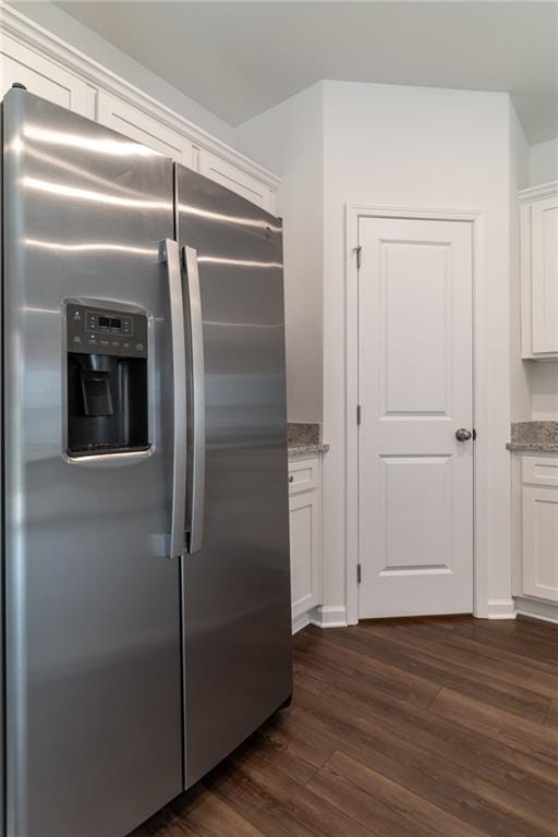 kitchen featuring white cabinetry, dark wood-style flooring, light stone countertops, and stainless steel refrigerator with ice dispenser