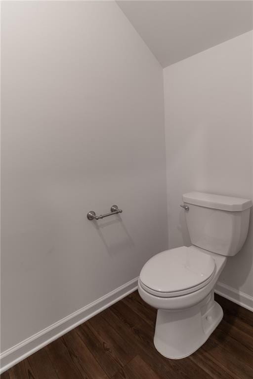 bathroom featuring baseboards, vaulted ceiling, toilet, and wood finished floors