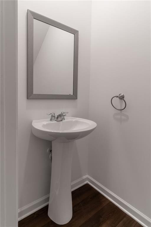 bathroom with baseboards and wood finished floors