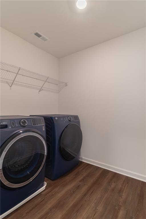laundry area with independent washer and dryer, visible vents, baseboards, laundry area, and dark wood finished floors