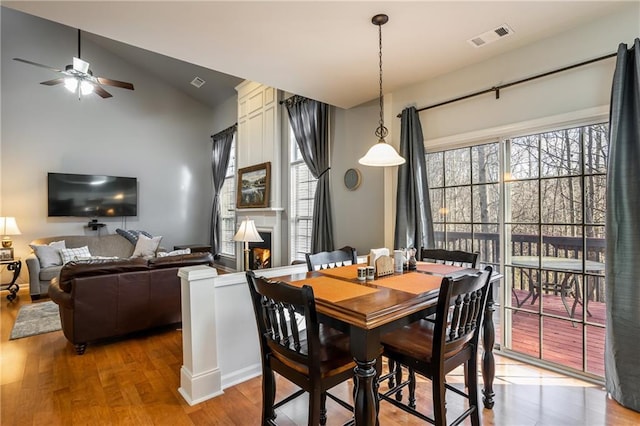 dining area featuring hardwood / wood-style floors, ceiling fan, and lofted ceiling