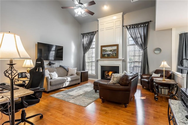 living room featuring ceiling fan, hardwood / wood-style floors, and high vaulted ceiling