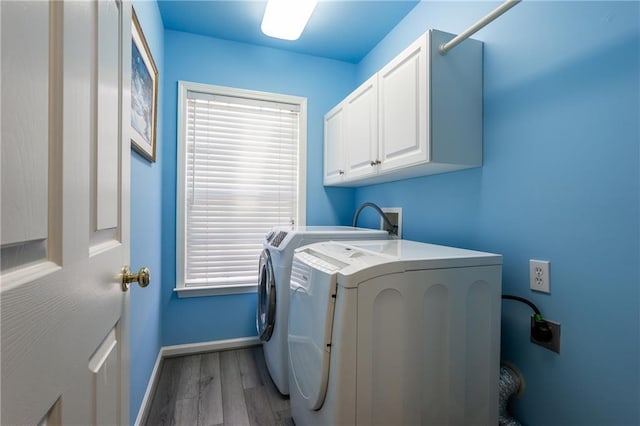 laundry room featuring cabinets, hardwood / wood-style floors, and separate washer and dryer