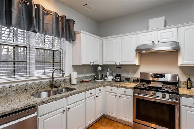 kitchen featuring light stone countertops, white cabinetry, sink, and appliances with stainless steel finishes