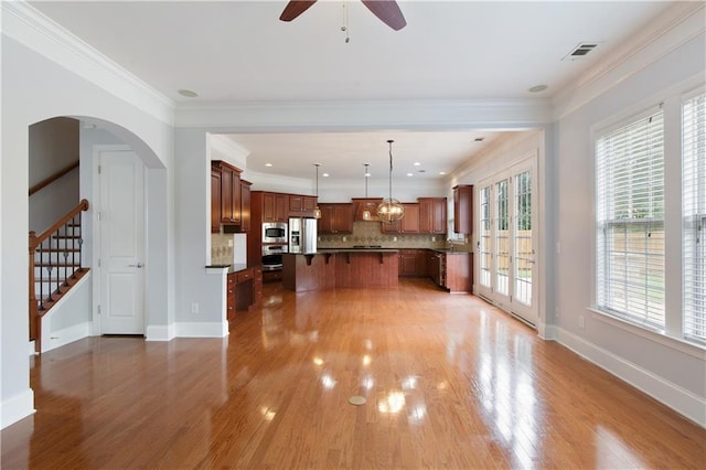 4652 Prater Way SE, Smyrna, GA 30080 - kitchen with stainless steel appliances, a breakfast bar, plenty of natural light, light wood-style flooring, and ornamental molding
