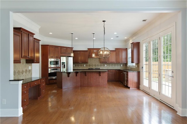 4652 Prater Way SE, Smyrna, GA 30080 - kitchen with stainless steel appliances, a kitchen breakfast bar, decorative backsplash, wood finished floors, and crown molding