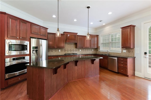 4652 Prater Way SE, Smyrna, GA 30080 - kitchen with appliances with stainless steel finishes, custom exhaust hood, a center island, wood finished floors, and a breakfast bar