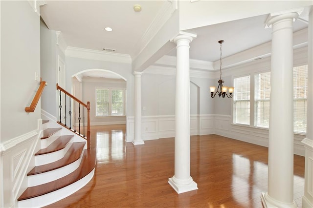 4652 Prater Way SE, Smyrna, GA 30080 - foyer entrance featuring wood finished floors, crown molding, arched walkways, a decorative wall, and a wainscoted wall