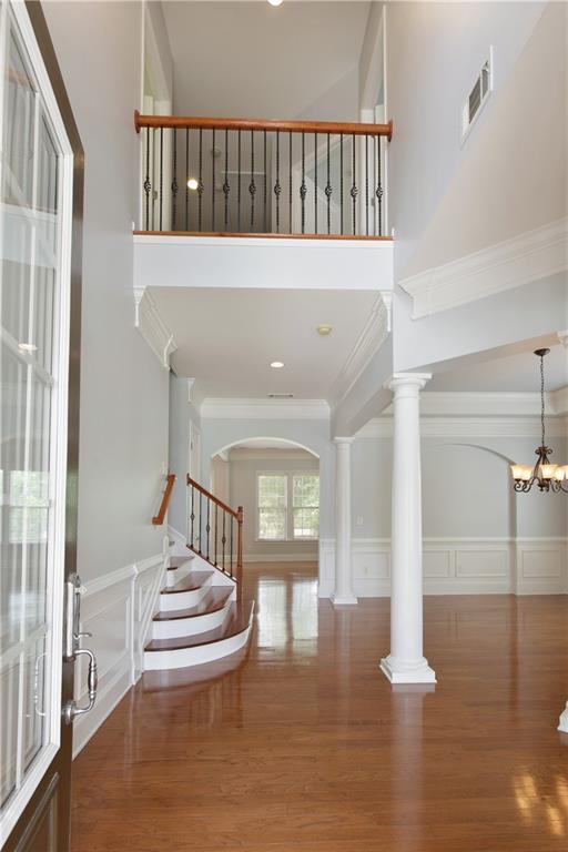 4652 Prater Way SE, Smyrna, GA 30080 - foyer featuring a decorative wall, a high ceiling, wood finished floors, stairway, and arched walkways