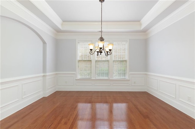 4652 Prater Way SE, Smyrna, GA 30080 - unfurnished dining area with a chandelier, wood finished floors, a wainscoted wall, a raised ceiling, and ornamental molding