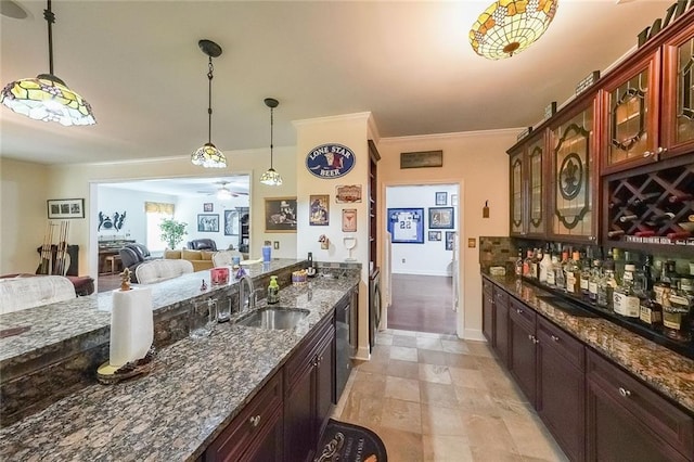 kitchen featuring ceiling fan, hanging light fixtures, dishwasher, a sink, and open floor plan