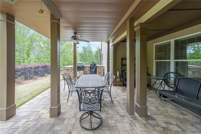 view of patio with ceiling fan, fence, and outdoor dining space