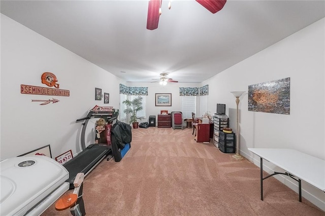 workout area featuring baseboards, carpet, and a ceiling fan