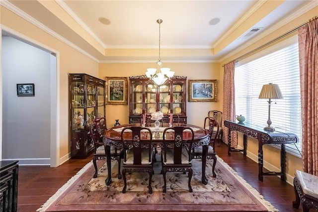 dining room with crown molding, baseboards, a raised ceiling, dark wood-style floors, and an inviting chandelier