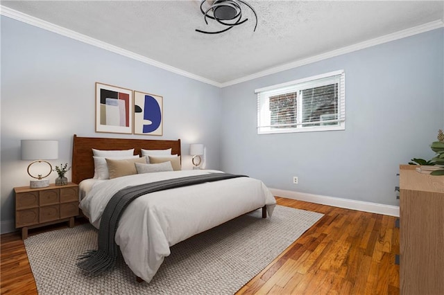 bedroom with hardwood / wood-style floors, a textured ceiling, and ornamental molding