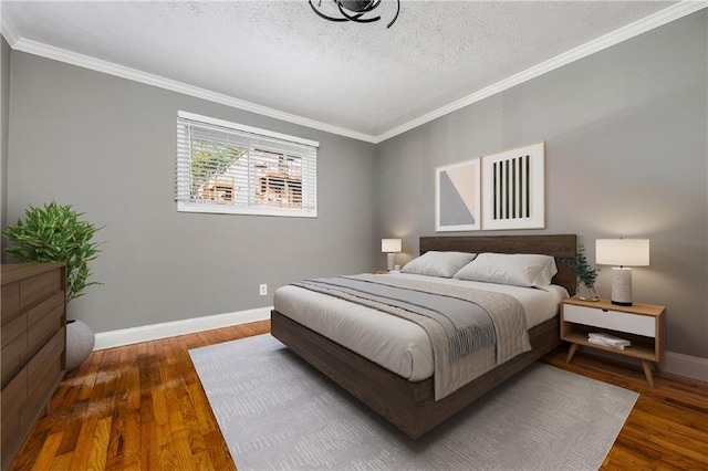 bedroom with dark hardwood / wood-style flooring, ornamental molding, and a textured ceiling