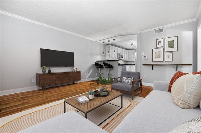 living room with light wood-type flooring and crown molding