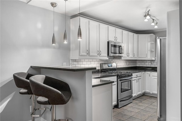 kitchen featuring stainless steel appliances, kitchen peninsula, pendant lighting, a breakfast bar area, and white cabinets