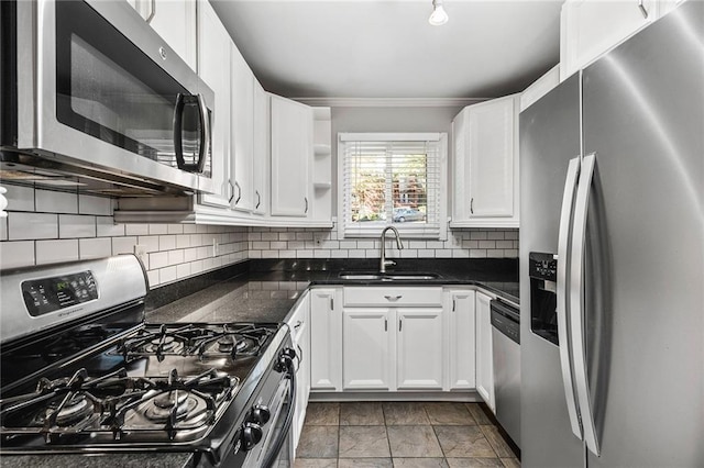 kitchen with crown molding, sink, decorative backsplash, white cabinetry, and stainless steel appliances