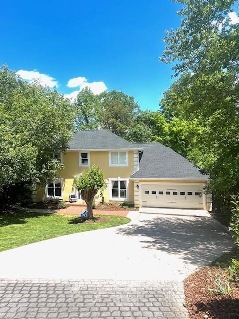 1536 Enota Ave, Gainesville, GA 30501 - colonial home featuring driveway, a front lawn, an attached garage, a shingled roof, and stucco siding