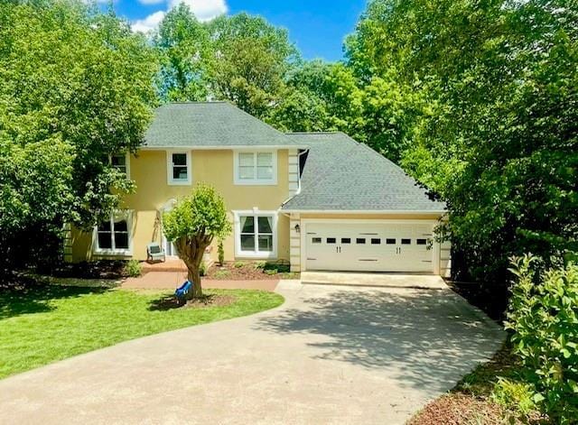 1536 Enota Ave, Gainesville, GA 30501 - view of front of house featuring an attached garage, a front lawn, stucco siding, and concrete driveway