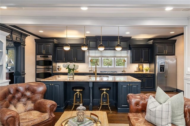 kitchen featuring appliances with stainless steel finishes, open floor plan, and light stone countertops