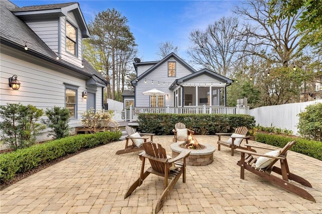 view of patio / terrace featuring fence, a fire pit, and a wooden deck