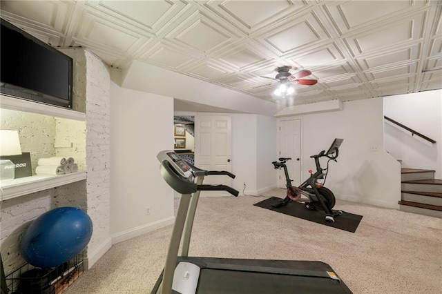 exercise area featuring carpet, an ornate ceiling, and baseboards