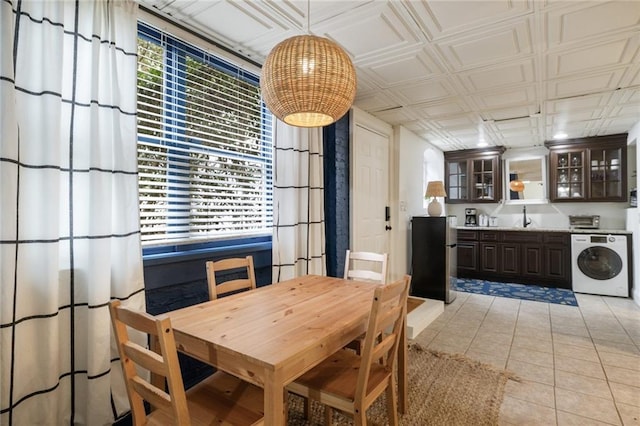 dining area featuring washer / dryer, an ornate ceiling, and light tile patterned flooring