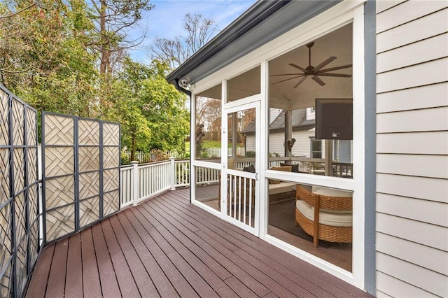 deck with a sunroom and a ceiling fan