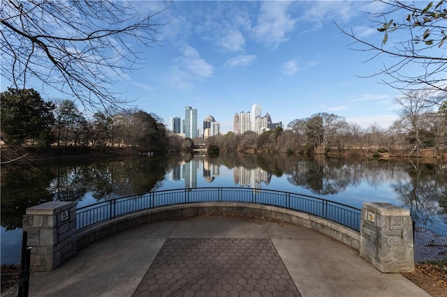 view of property's community with a water view, fence, and a city view