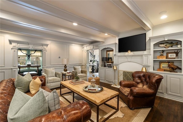 living room featuring crown molding, a decorative wall, beamed ceiling, and wood finished floors