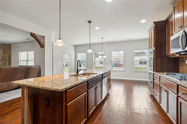 kitchen with a kitchen island with sink, dark hardwood / wood-style flooring, sink, and plenty of natural light