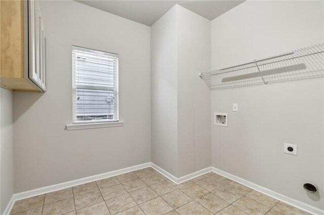 laundry area with washer hookup, electric dryer hookup, light tile patterned floors, and cabinets