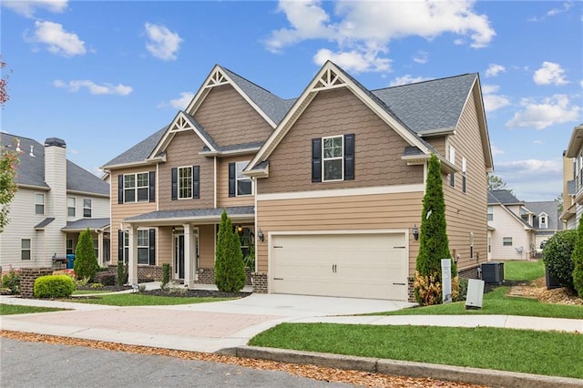 craftsman inspired home featuring central AC unit and a garage