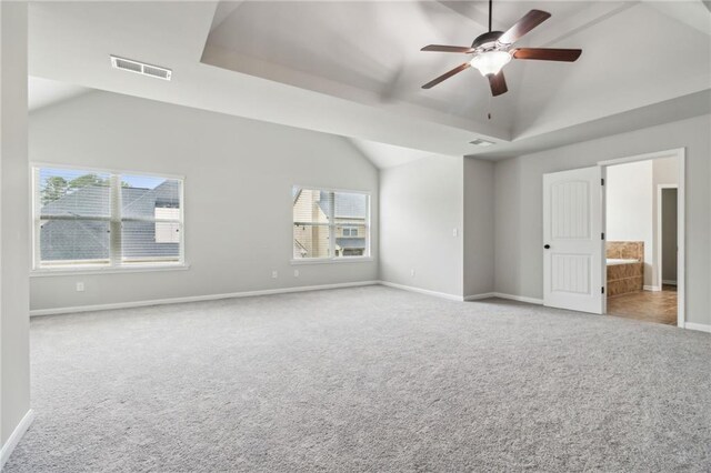 unfurnished bedroom featuring connected bathroom, lofted ceiling, light colored carpet, and ceiling fan