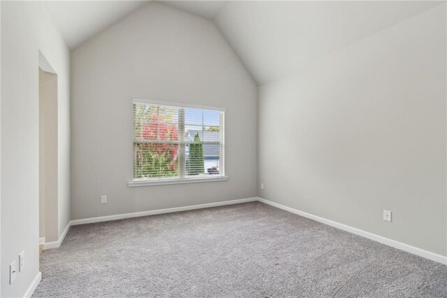 empty room featuring vaulted ceiling and carpet floors