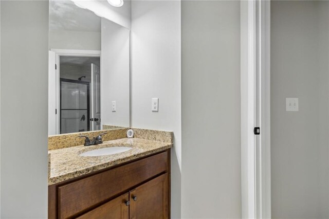 bathroom with a shower with door and vanity