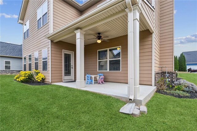 back of property featuring a lawn and ceiling fan