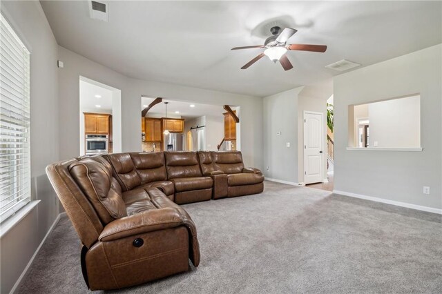 living room featuring carpet flooring and ceiling fan