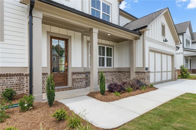 entrance to property featuring a porch and a garage