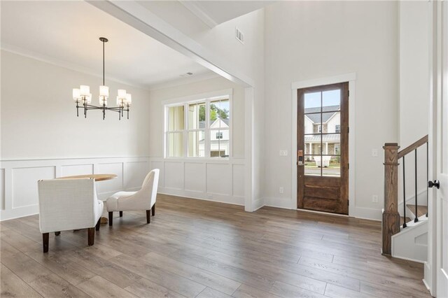 dining space with a chandelier, wood-type flooring, and crown molding